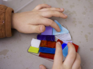 Child's hands working with glass arts