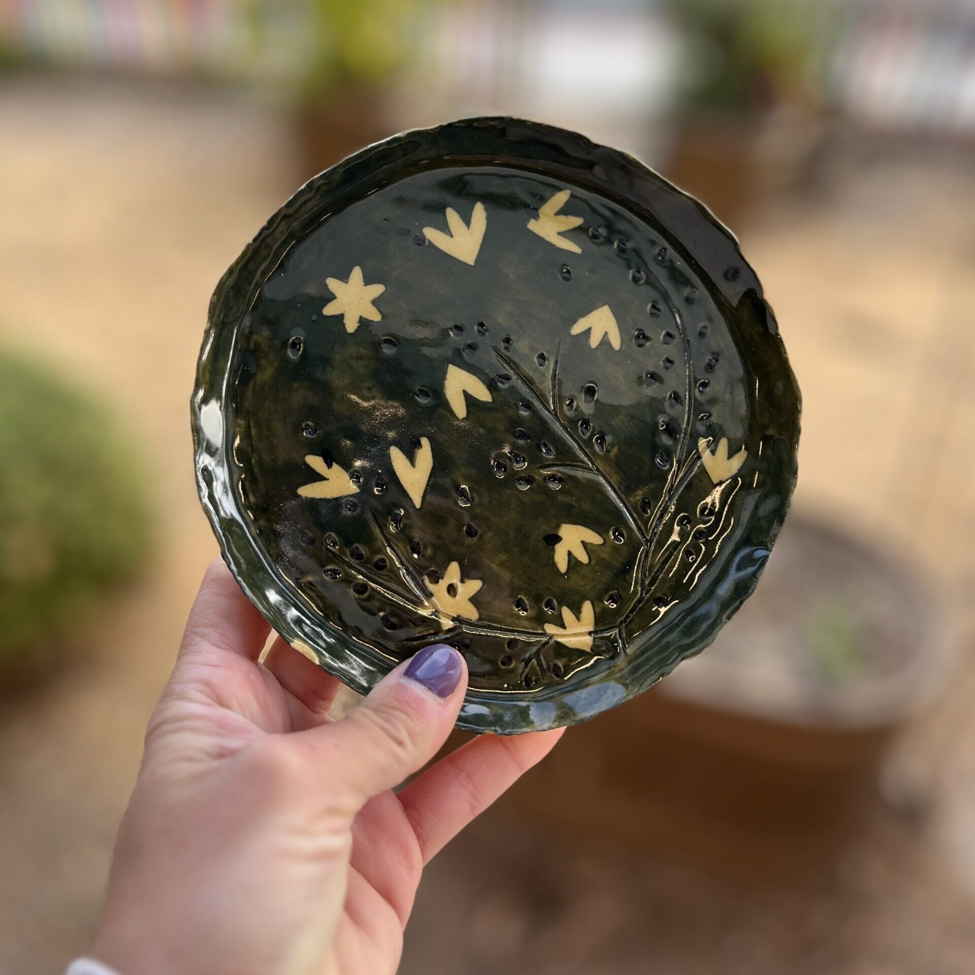 hand holding handmade bowl with surface design technique