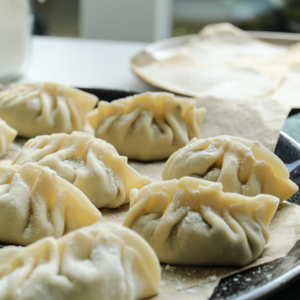 dumplings sitting on baking sheet lightly dusted with flour