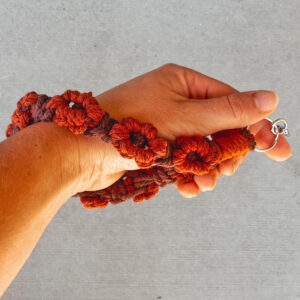 hand holding macrame' phone leash on wrist