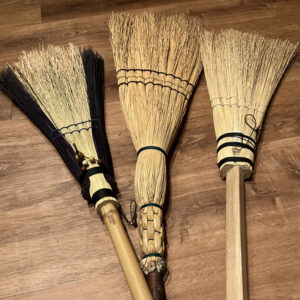 close up of three handmade brooms